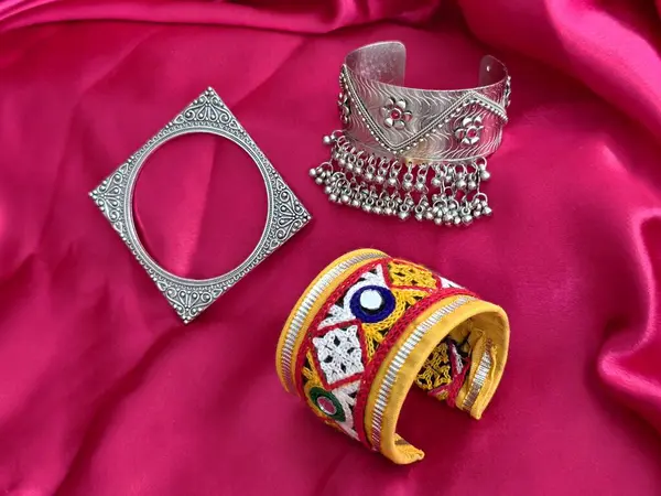 Geleneksel kumaş ve oksitlenmiş bilezikler pembe saten üzerinde, Navratri kutlamaları için mükemmel ve el yapımı bir cazibeyle şenlikli etnik görünüş..