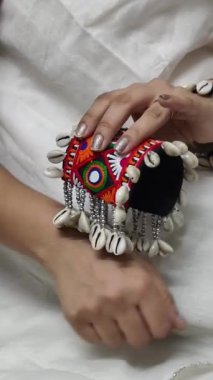 El yapımı işlemeli kumaş bir ada ve kodi kabukları ve boncuklar, garba oynarken geleneksel Navratri kıyafetleri için mükemmel bir aksesuar..