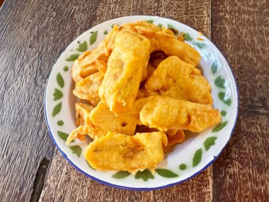 Lezzetli kızartılmış atıştırmalıklar kırsal bir ahşap masada sergilenen dekoratif bir tabakta servis edilir..