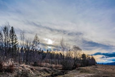Karlı güzel bir manzara - tepeli dağlar ve bulutlu mavi gökyüzü