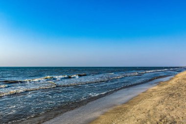 Dalgalı ve kumlu deniz kıyısı.