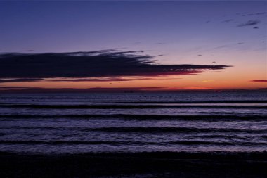 Sahilde gün doğumu Deniz ve bulutlarla