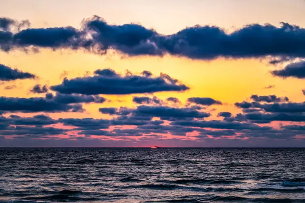 Denizin üzerinde bulutlar olan renkli dramatik gökyüzü. doğa bileşimi.