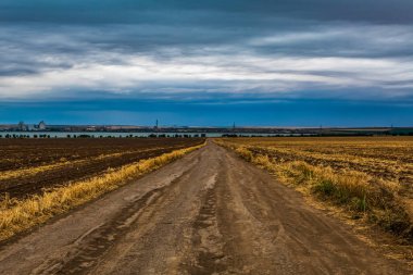 Bulutlu bir gökyüzü olan bir yolun dikey görüntüsü