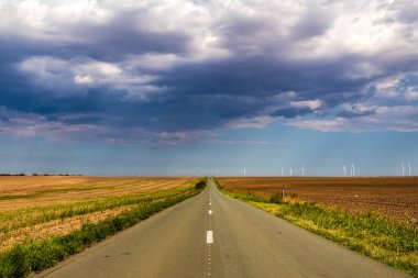 empty asphalt asphalt road with fields in the middle of the horizon