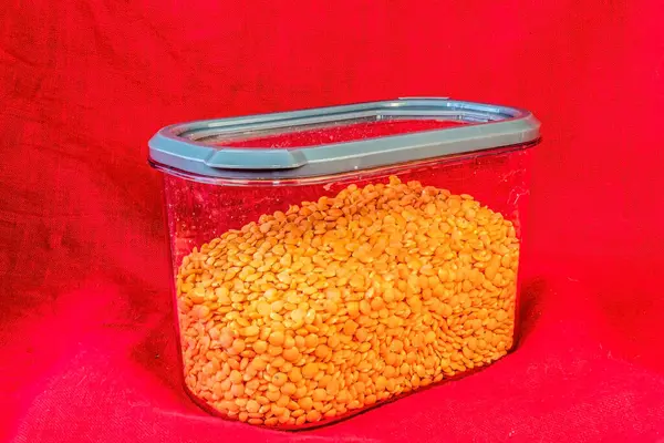 Kırmızı arka planda kırmızı havyarlı kırmızı cam kavanoz.