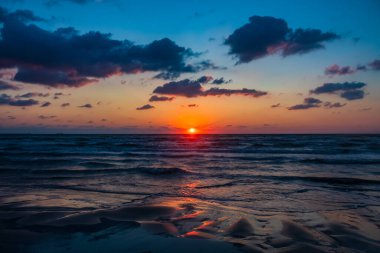 Denizin ve dalgaların üzerinde renkli bir gün batımı. Güzel gün batımı gökyüzü ve bulutlar. Doğa manzarası. doğa arkaplanı.