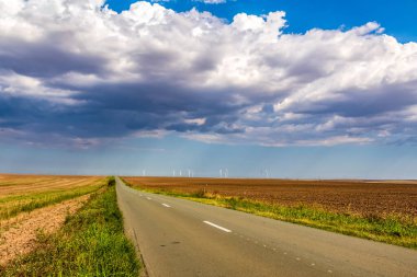 Kırsal bir yol ve arka planda bulutlu bir gökyüzü, Letonya