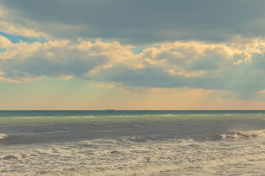 Deniz ve gökyüzü bulutlarla ve güneşle