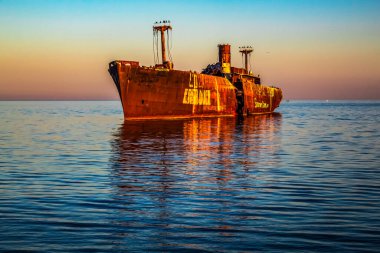 Yaşlı paslı çapayı kırmızı bir teknede gün batımında