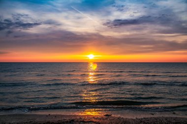Denizin üzerinde gün batımı.