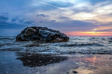 Denizin üzerinde gün batımı.