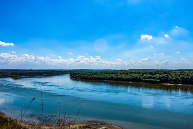 Nehir ve mavi gökyüzü olan güzel bir manzara.
