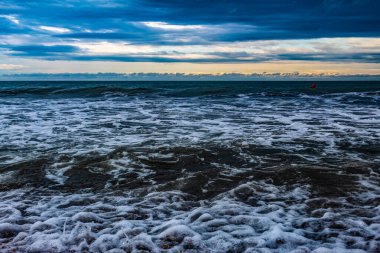 Sahilde akşam ışığında deniz dalgaları