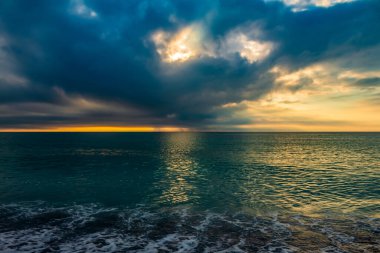 Denizin üzerinde dramatik bir gün doğumu. Dramatik gökyüzü. Denizin üzerinde renkli bulutlar.