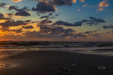 Baltık sahili, akşam ve dramatik bir fırtınada gün batımı ve mavi gökyüzü. resim gibi deniz manzarası, doğa ve cennet gibi deniz manzarası. Seyahat, tatiller