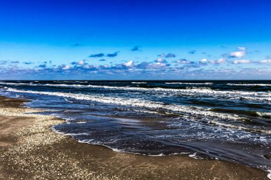 Güzel sahil ve mavi gökyüzü deniz dalgalarıyla