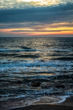 Gün batımında güzel bir denizin dikey çekimi.