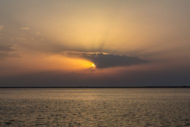 Denizde gün batımı Küçük bir gemiyle