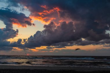 Gün batımında denizin üzerinde dramatik bulutlar