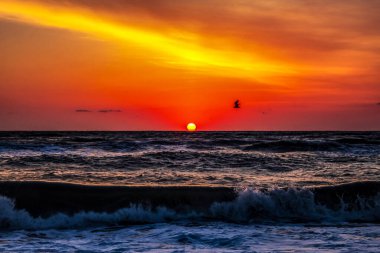 Gün batımı denizin üzerinde güzel dalgalarla