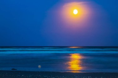 Ay ve deniz gün batımında