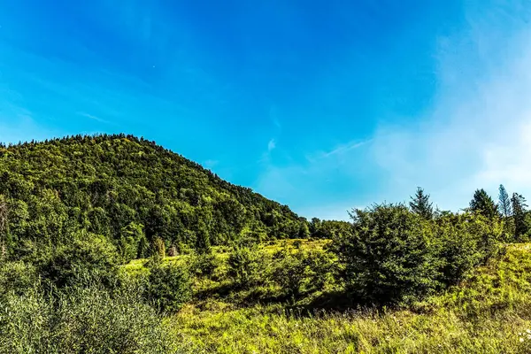 Dağları ve mavi gökyüzü olan güzel bir manzara.