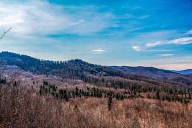 Dağları ve mavi gökyüzü olan güzel bir manzara.