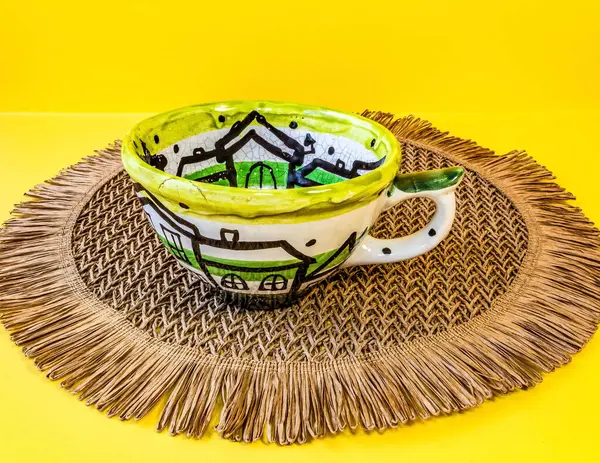 Bir fincan kahve ve yeşil yaprağın dikey görüntüsü.