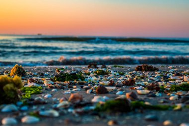 Yaz mevsiminde deniz üzerinde gün doğumu ve kayalar