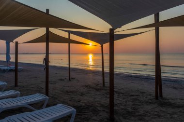 gün batımında sahilde şezlong