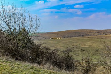 Arkasında yeşil çimenler ve mavi gökyüzü olan güzel bir dağ manzarası