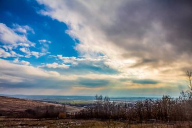 Bulutları ve mavi gökyüzü olan güzel bir manzara.