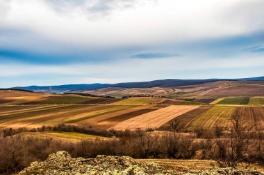 Arkasında tarlalar ve tepeler olan manzara