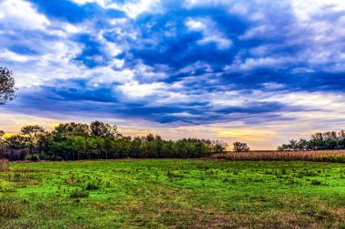 Bulutlu gökyüzü ile tarlada güzel bir gün batımı