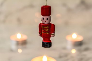 Noel Baba heykelciği ahşap bir masada yanan bir mumla melek şeklinde.