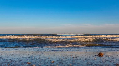 Güzel mavi bir okyanusta su sıçrayan deniz dalgaları.