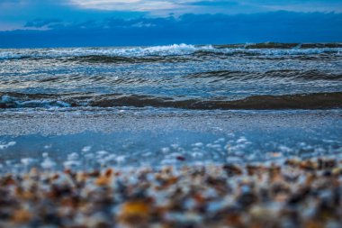 Kışın kumsalda kar ve dalgalarla