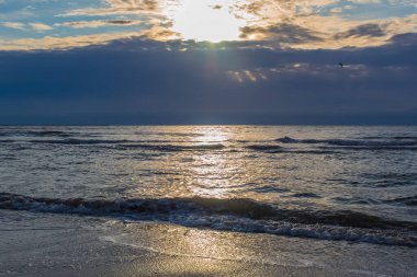 Gün batımında sahilde deniz dalgaları