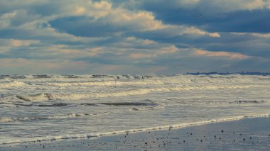 Gün batımında Baltık Denizi 'nde dalgalar, Polonya.