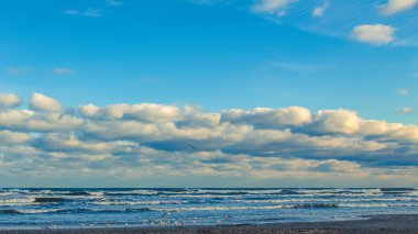 Baltık deniz kıyıları, akşam gökyüzü, parlayan bulutlar.