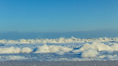 Kar ve beyaz köpüklü mavi gökyüzü ile kış deniz manzarası