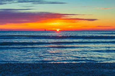 Sahilde, denizde ve gökyüzünde güzel bir gün batımı