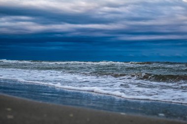 Akşam denizindeki fırtına bulutları dalgalar ve ufuklarda sıçramalarla.