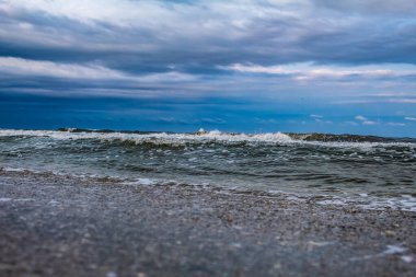 Fırtınalı deniz dalgaları ve mavi gökyüzü.