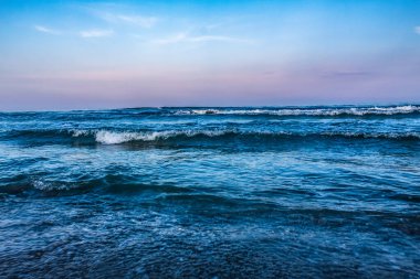 Mavi denizde dalgalar Yazın kumsalda güneşli bir günde