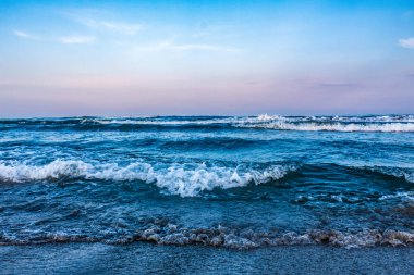 Sahilde gün batımında denizin dalgaları