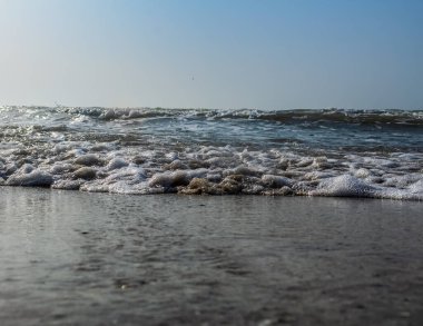 Kumsalda deniz dalgaları ve köpük