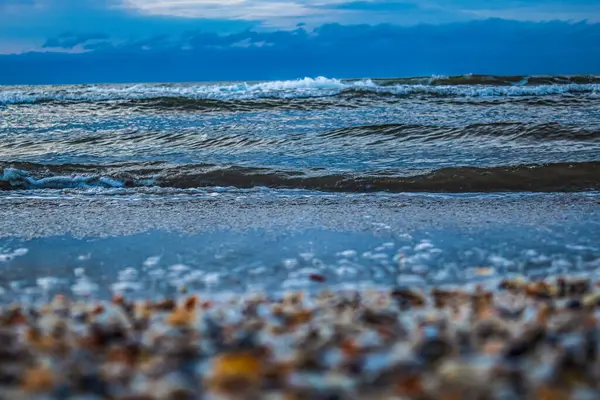 Kışın kumsalda kar ve dalgalarla