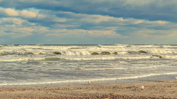 Baltık denizi, bulutlu bir gökyüzü, resimli bir yaz manzarasında güneşli bir gün. Doğa, Letonya, turizm, seyahat, dinlenme, doğa ve